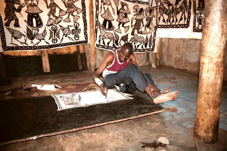 Artesano de Korhogó pintando un tapiz